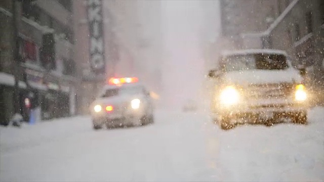 在纽约市的冬天，警车在被雪覆盖的街道上追逐。纽约警局预防犯罪和公共安全部门视频素材