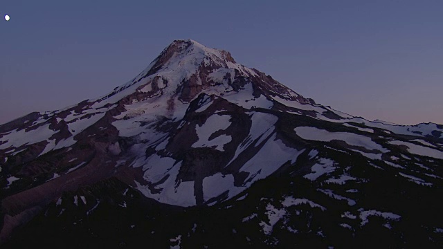 月光下白雪覆盖的胡德山山顶的航拍图。视频素材