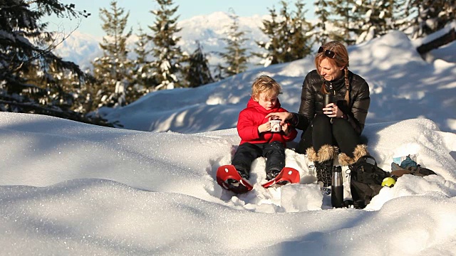 白人母亲和儿子在雪中喝可可视频素材