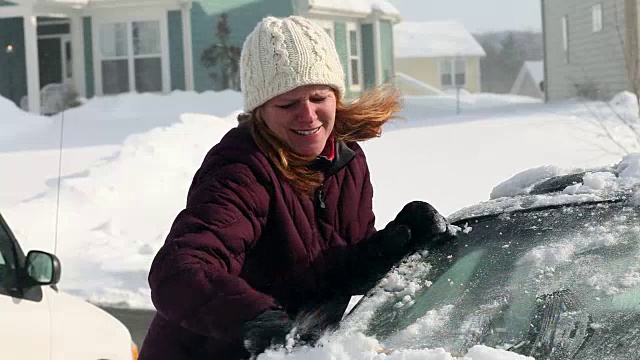 白人妇女从车里刮雪视频素材