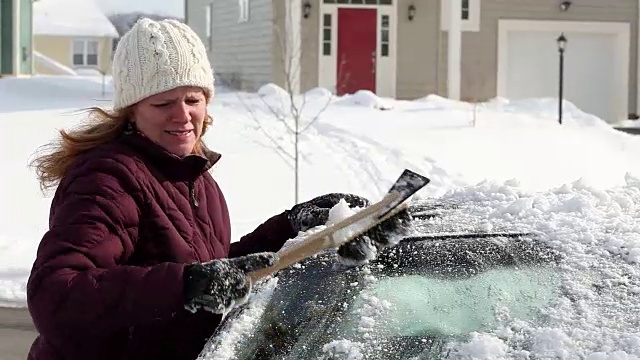 白人妇女从车里刮雪视频素材