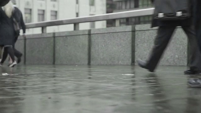 视频网站循环显示，通勤者在下雨的街道上行走视频素材