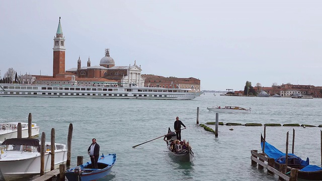 意大利威尼托威尼斯，游客在Molo Riva degli Schiavoni的贡多拉上享受旅程，游轮经过视频素材