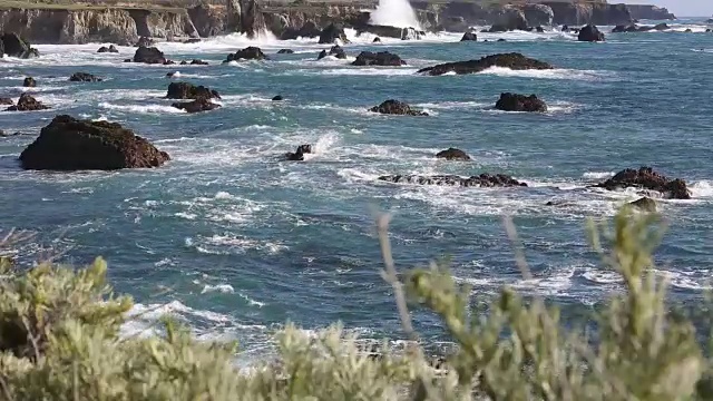 大苏尔的岩石海岸线，海浪拍打着海岸，阳光照耀着。视频素材