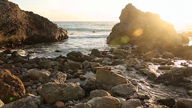 大苏尔的岩石海岸线，海浪拍打着海岸，阳光照耀着。视频素材