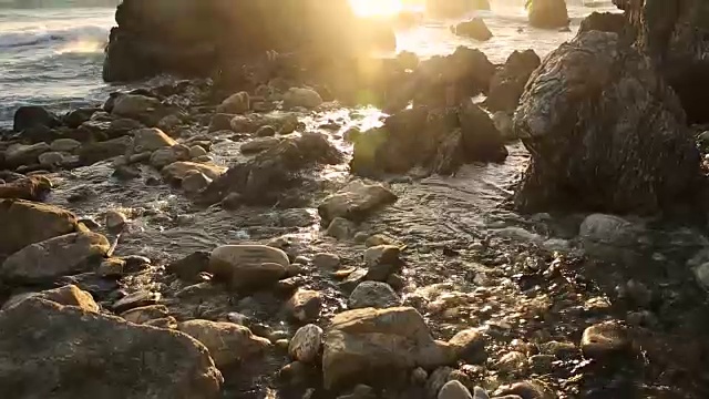 大苏尔的岩石海岸线，海浪拍打着海岸，阳光照耀着。视频素材