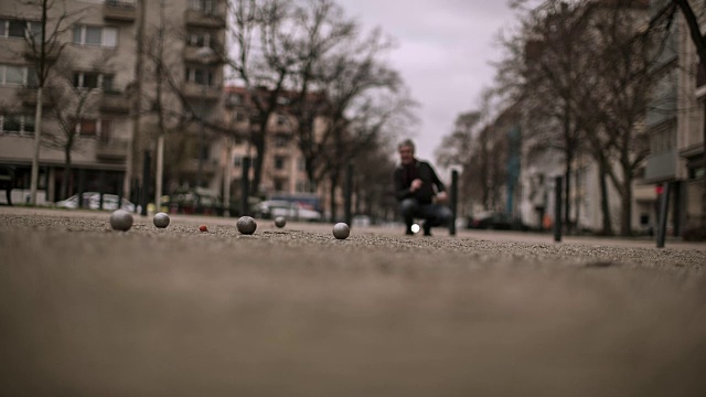 一位活跃的老人在柏林库尔夫街(Kurf)附近的一条小街上玩球视频素材