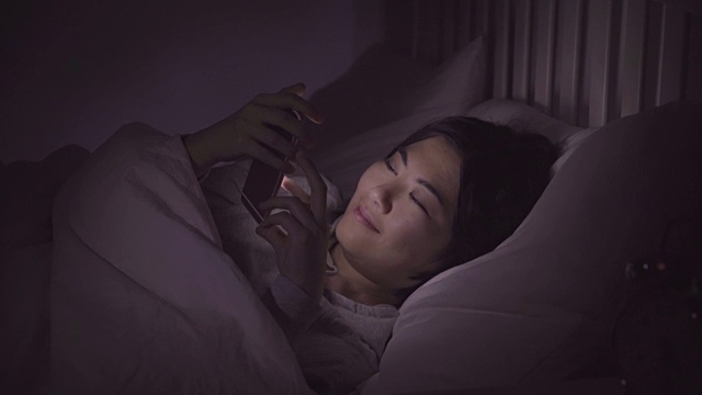 床上电话留言。亚洲女性睡眠中断。视频素材