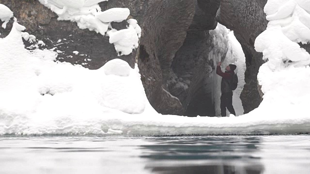 徒步旅行者走进河边的雪洞视频素材