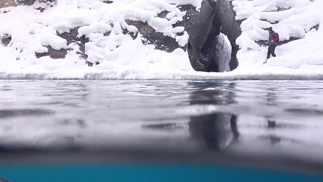 徒步旅行者走进河边的雪洞视频素材