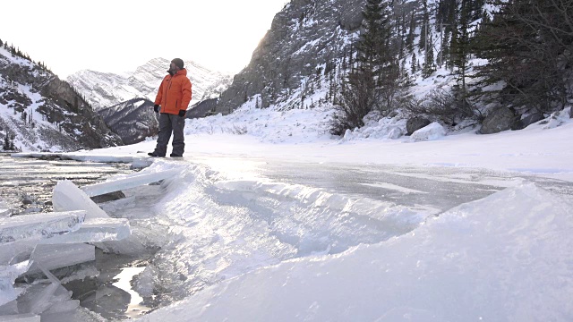 徒步旅行者沿着河边的积雪小径行走视频素材