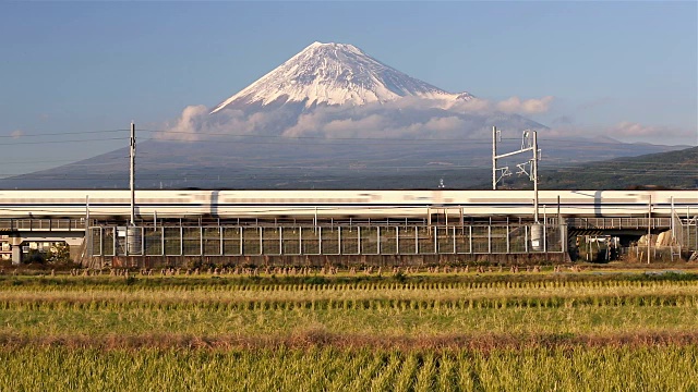 日本，本州，富士山，新干线子弹列车通过收获的稻田下的积雪覆盖的火山视频素材