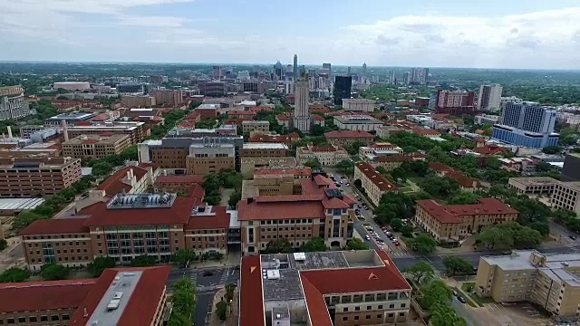 flying away Orange rooftop Campus UT Tower Aerial Fly by Austin Texas Over Texas University at Austin Capital Cities with Downtown Cityscape Skyline in the background at Center向前靠近游泳池、令人惊叹的建筑和教堂视频素材