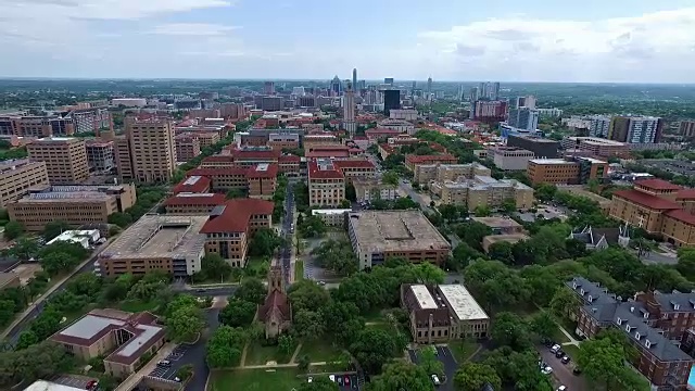 真的远广角校园UT塔空中飞行的德克萨斯大学在奥斯汀首都城市与市中心城市天际线的背景在中心向前靠近游泳池和令人惊叹的建筑和教堂视频素材