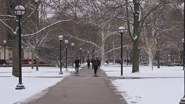 学生们走过冰雪覆盖的校园视频素材