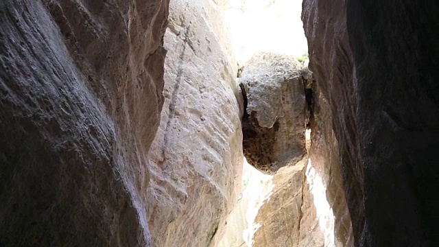 徒步旅行的夫妇探索深深的峡谷，与头顶的木楔石视频素材