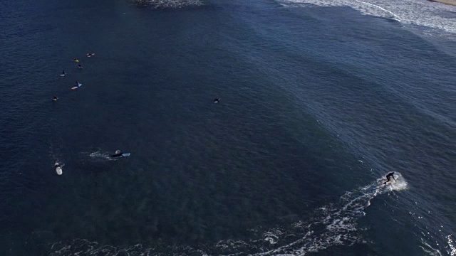 在Jukdo海滩冲浪的人们和海水冲上海岸的鸟瞰图视频素材