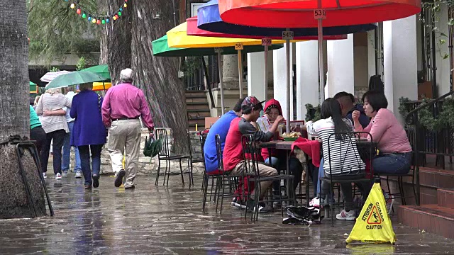 德克萨斯州圣安东尼奥的人们从雨伞旁走过视频素材