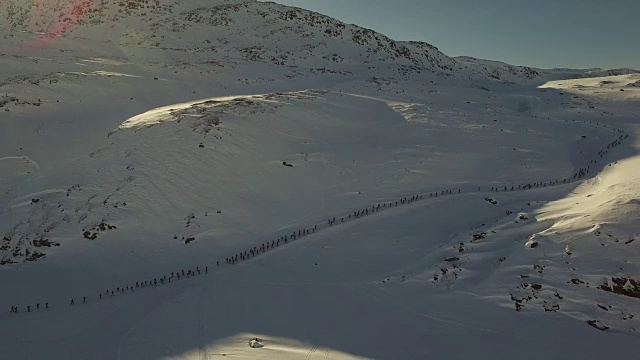 太阳升起的时候，一群滑雪者跑上山的无人机镜头视频下载