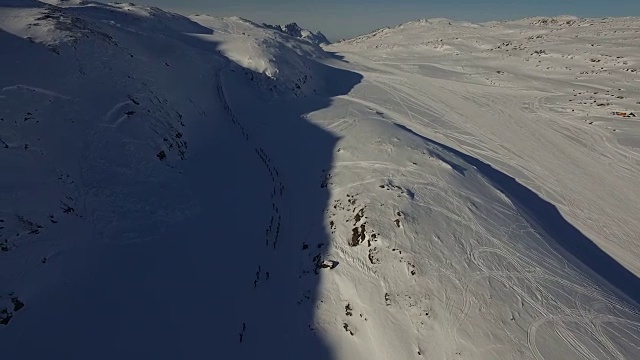 一组滑雪运动员在格陵兰山区比赛的无人机镜头视频下载