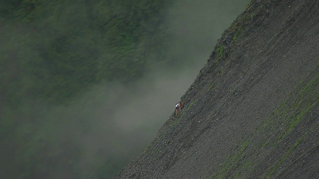 在美国阿拉斯加州苏厄德举行的山地马拉松比赛中，一组选手坐在山的一边，另一个人正在爬山视频素材