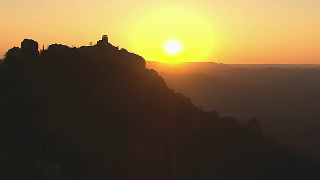 在彭宁顿县哈尼峰消防塔后面的轨道的WS鸟瞰图，夕阳沿着消防塔和山的边缘/南达科他，美国视频素材