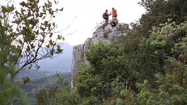 父子俩停了下来，徒步前往山谷之上的崖顶视频素材