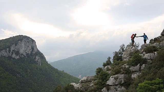 徒步夫妇攀登岩石山脊山脊之上的山谷，山脉视频素材