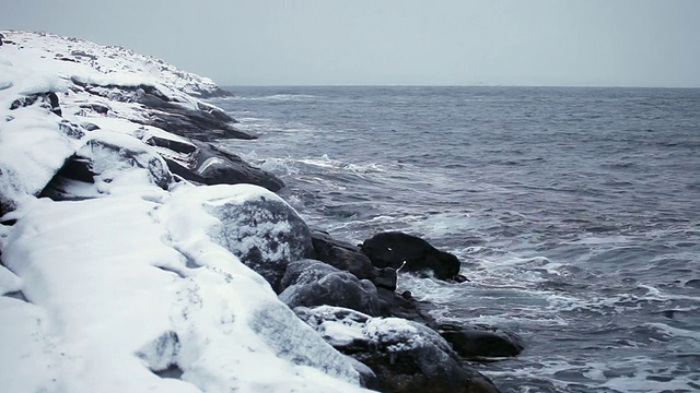 海湾里的水被白雪覆盖的海岸包围着视频素材