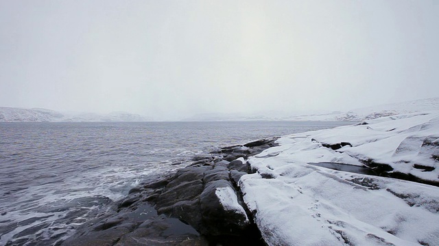 海湾里的水被白雪覆盖的海岸包围着视频素材