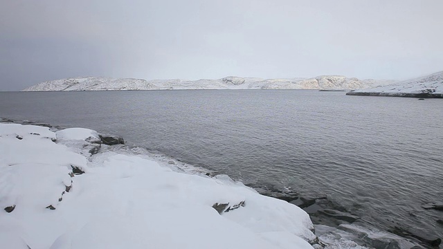 海湾里的水被白雪覆盖的海岸包围着视频素材