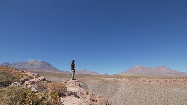 在沙漠里看着火山的女人视频素材