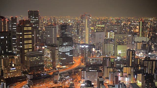 高角度的城市交通夜景，大阪，日本，与地铁列车穿透高层建筑隧道视频素材