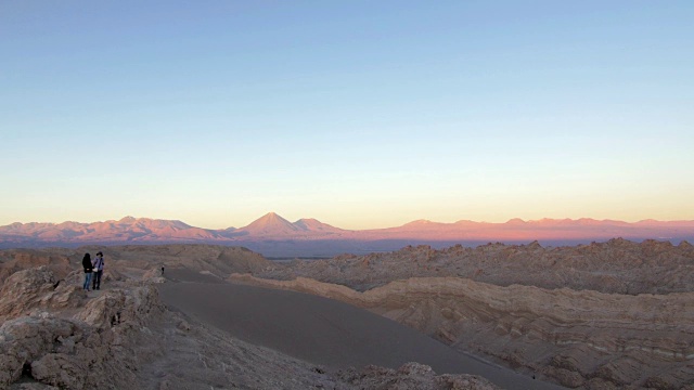 日落时分，两个女人在沙漠山上聊天视频素材