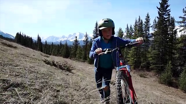 男孩推着自行车上山，山上视频素材