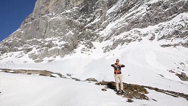 一名男性徒步旅行者将雪球扔向照相机，山脉视频素材