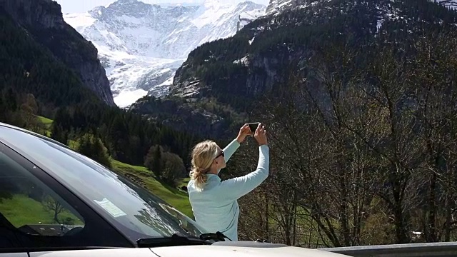 女人下车，在雪山上拍照视频素材