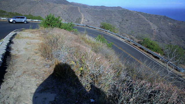 在美国加州圣塔莫尼卡/威尼斯，汽车在多风的道路上行驶，俯瞰大海视频下载