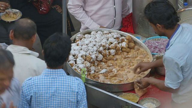 印度新德里，一名男子在市场上供应食物视频素材