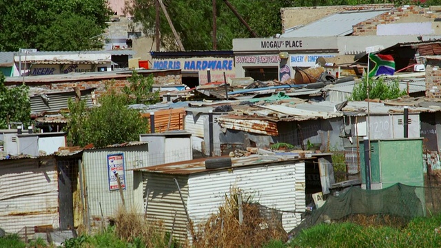 城镇中的房屋和棚屋，南非国旗随风飘扬/ Diepsloot，南非视频素材