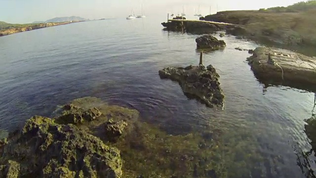 西班牙伊比沙岛的小船和岩石海岸线鸟瞰图视频素材