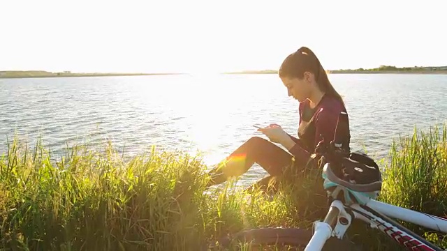 年轻女子在大自然中使用智能手机。视频素材