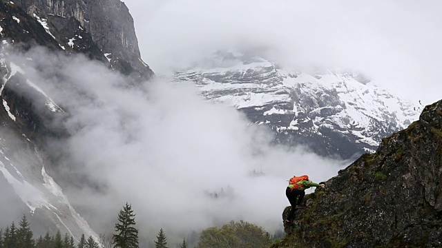 一名女性徒步者在攀登雪山下的山脊时停下来视频素材