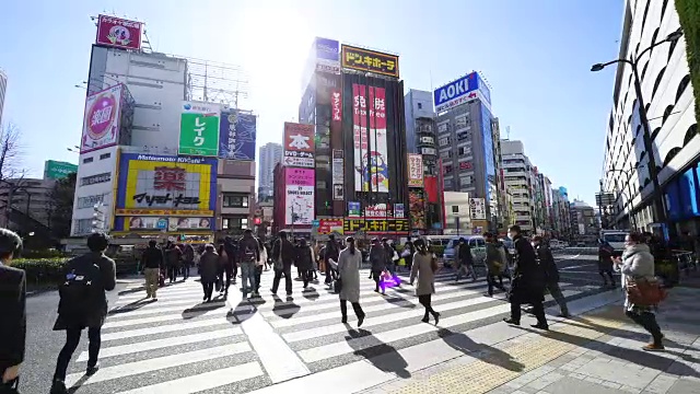 池袋站清晨通勤拥挤的景象。早上池袋车站前的行人过人行横道。视频素材