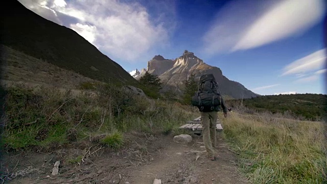 一个背包客徒步旅行，后面有一些山视频素材