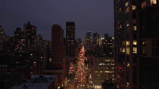 灯光照亮的城市街道和建筑物的夜间拍摄。纽约市风景视频素材