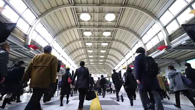 在JR品川站彩虹路通道，早上上下班的人群非常拥挤。JR品川站彩虹路的清晨通勤场景。视频素材