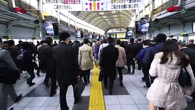 在JR品川站彩虹路通道，早上上下班的人群非常拥挤。JR品川站彩虹路的清晨通勤场景。视频素材