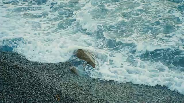 浪花拍打在卵石上，特写视频素材