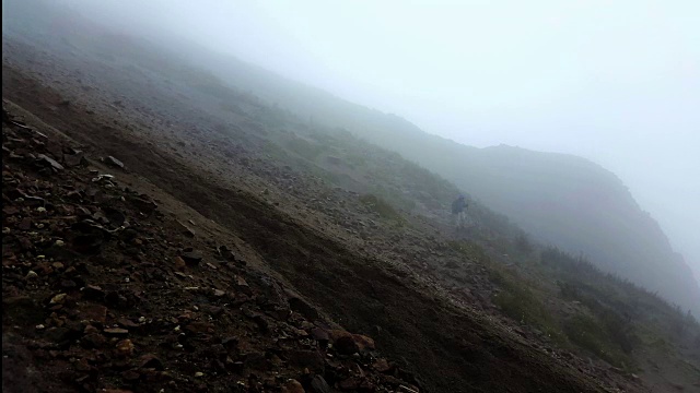 一名男子在厄瓜多尔基多皮钦查山徒步旅行，云雾缭绕，大雨倾盆视频下载